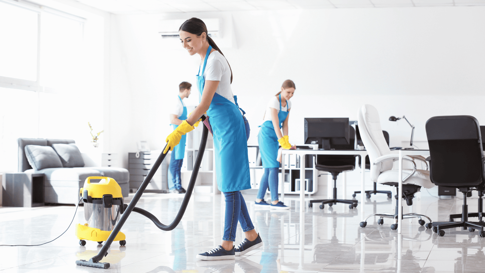 Office cleaning team vacuuming and sanitizing workspaces for businesses in New Castle County DE